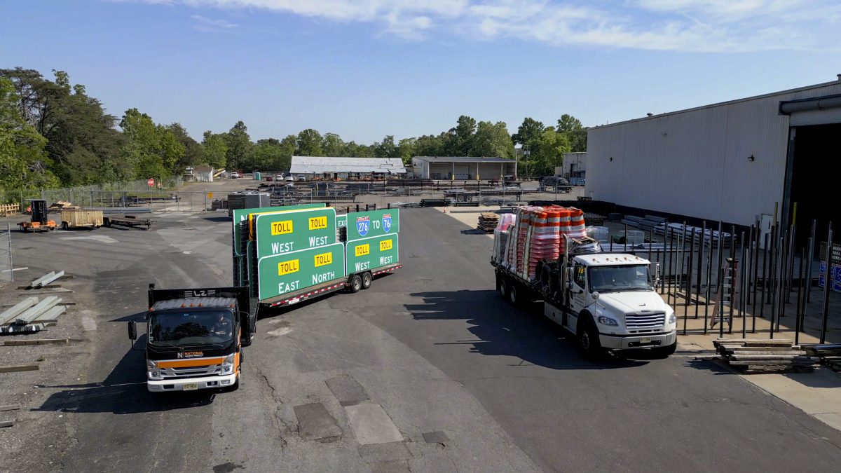 National Highway Products trucks hauling guide signs and traffic drums